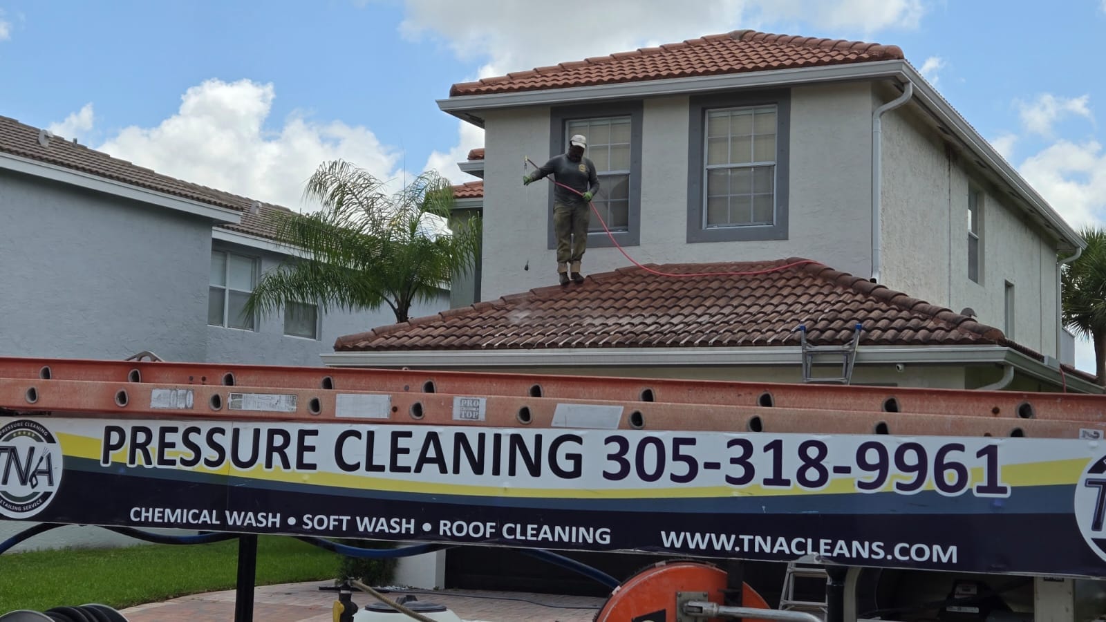TNA technician soft washing a tile roof in South Florida