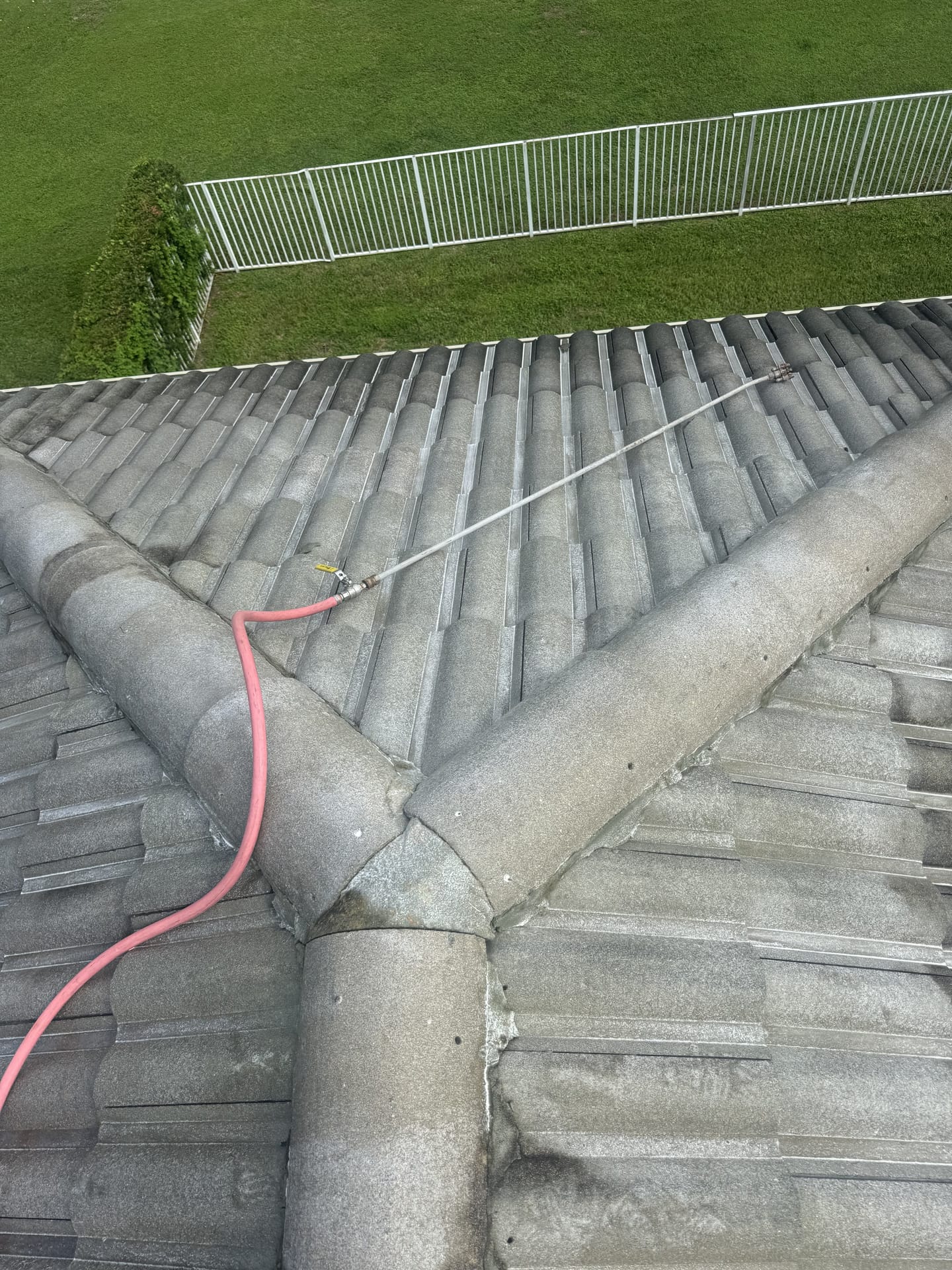 Removing algae and dirt from a tile roof with low-pressure soft wash