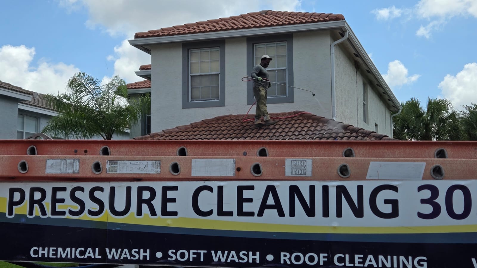 TNA crew member soft washing a residential tile roof