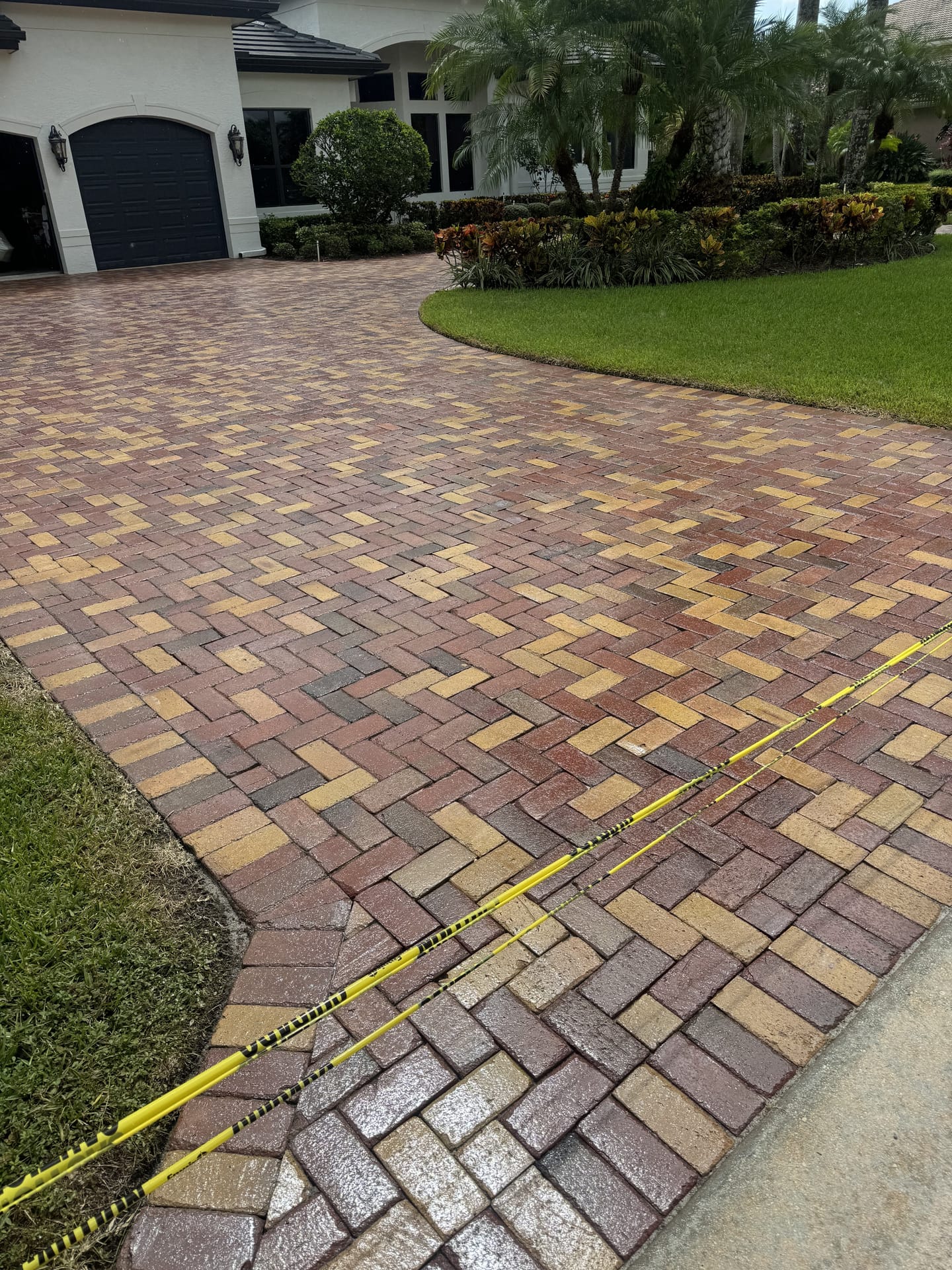 Freshly cleaned and sealed paver driveway at a luxury home